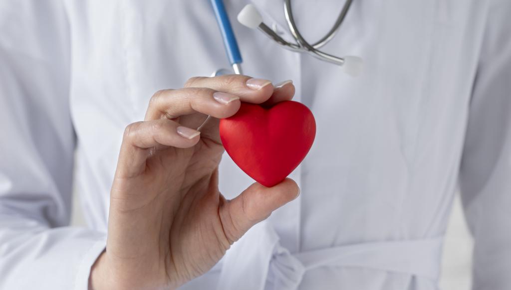 doctor-sosteniendo-corazon-rojo-cerca